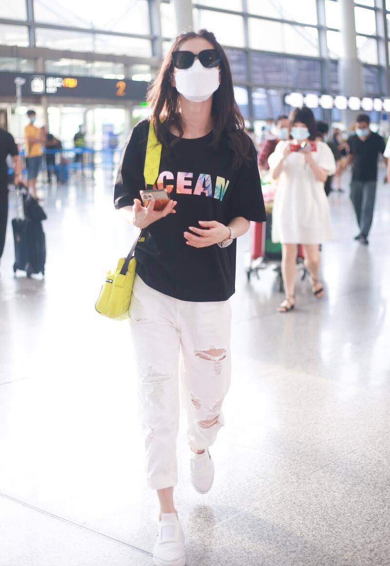 黄圣依现身北京机场,黑t恤搭配破洞牛仔裤,小黄包很醒目