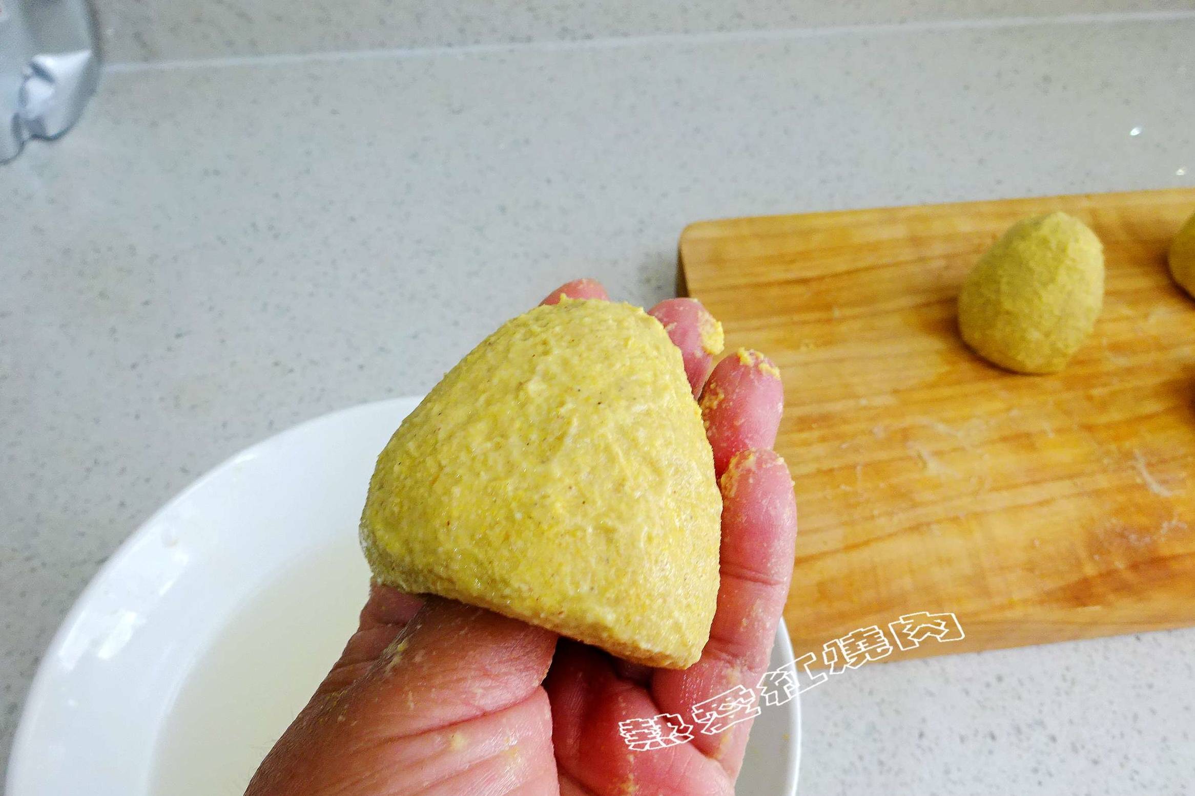 8手上沾水将每一份做成馒头状,用大拇指在下面戳个洞,这样蒸的时候