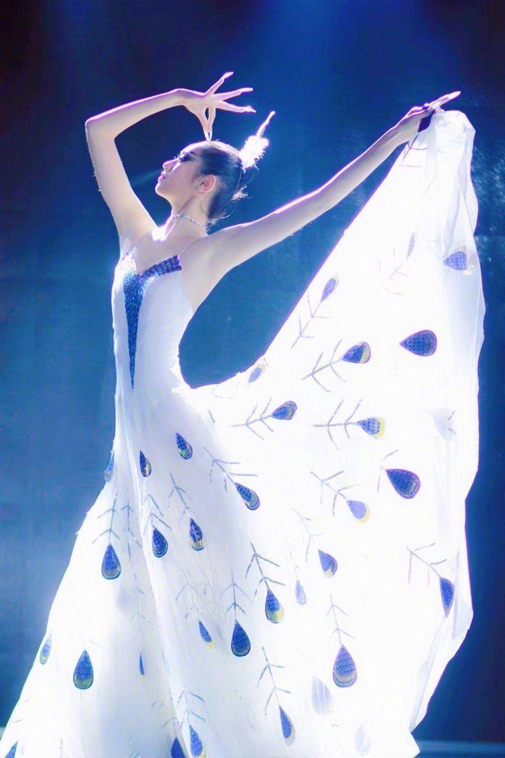 的身材,穿上舞蹈服,在舞台上的杨丽萍身穿吊带长裙,上面是孔雀的花纹