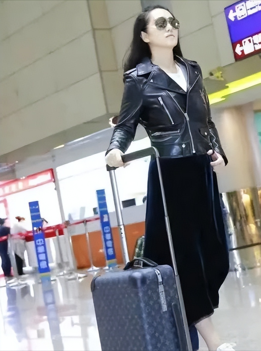 时尚穿搭技巧:短款黑皮衣 黑色半长裙 小白鞋巩俐在这次街拍中,选择了