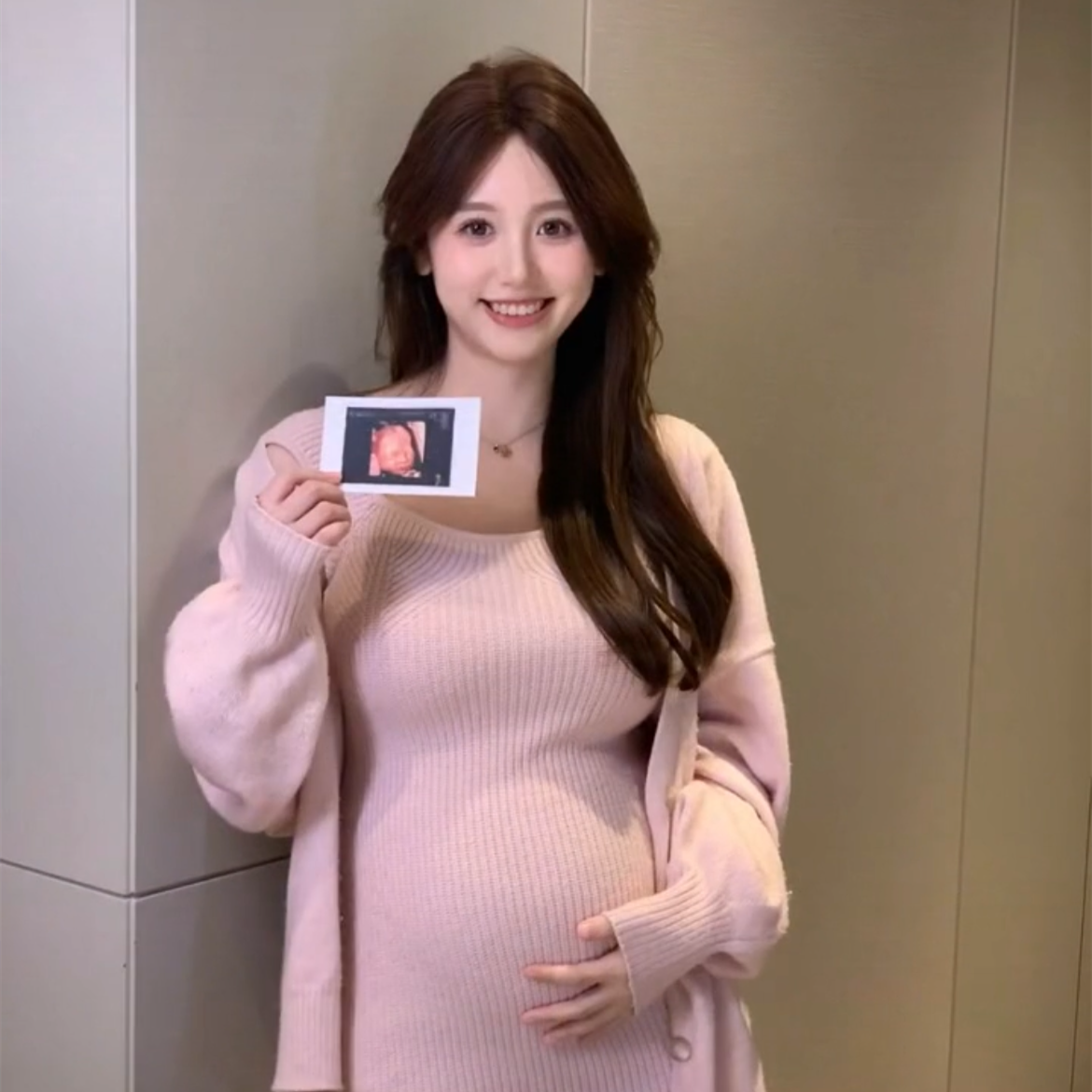 见的一栗小莎子一手举着宝宝的b超照,另外一只手则轻轻抚摸孕肚,清纯