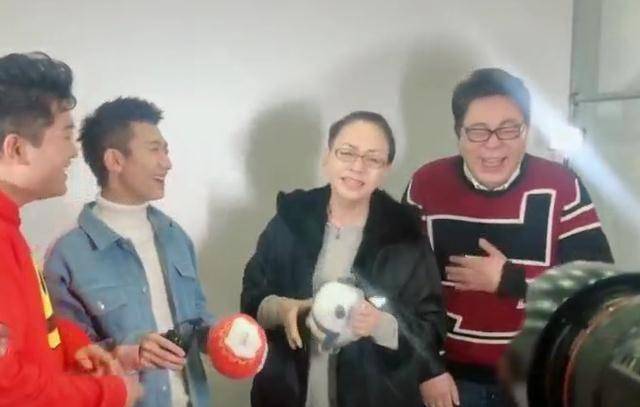 里面一件白色内搭,手里拿着话筒,宋丹丹站在中间,尤浩然和高亚麟站在