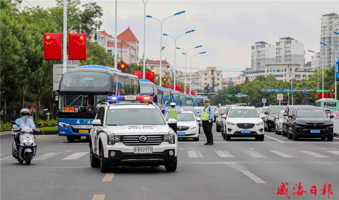 来自市公安局交警支队的民警忙着疏导交通,安排警车开路引导高考运输