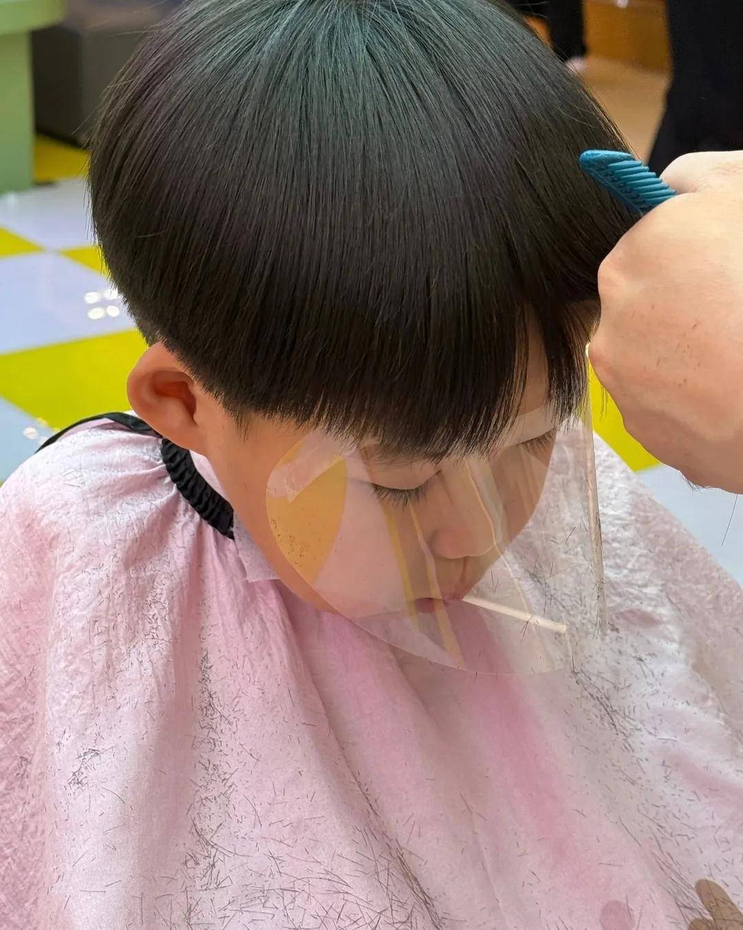 椅子上让理发师剪头妈妈廖雨辰还特意为他们准备好了各自合适的发型