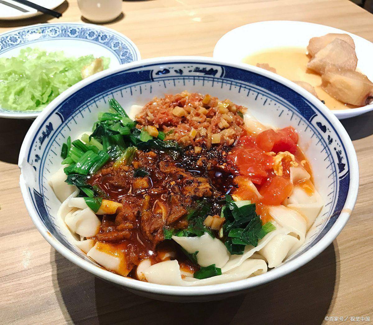 汤滚面翻,宛如"银鱼戏水",煮至九分熟时捞出,淋上秘制臊子,一碗刀削面