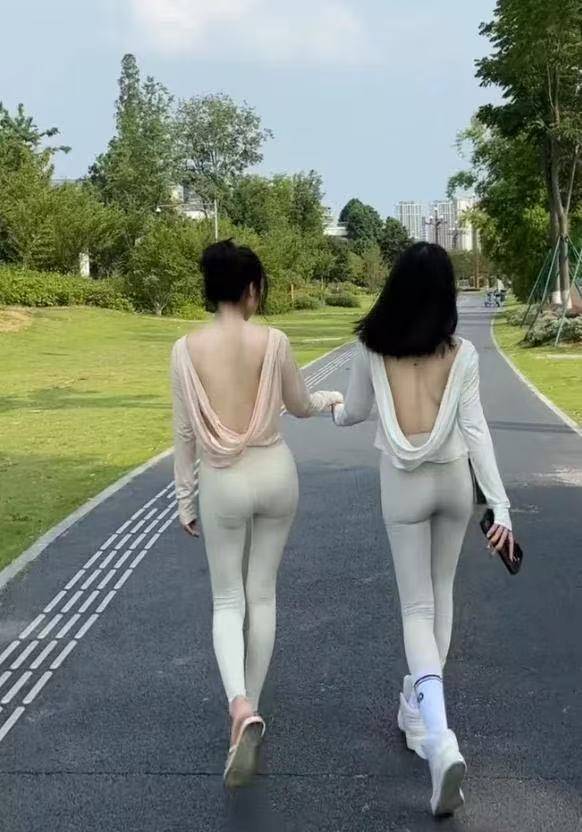 这两个妹子在公园穿瑜伽裤加露背装，要是拔上罐子就更好了，哈哈哈！