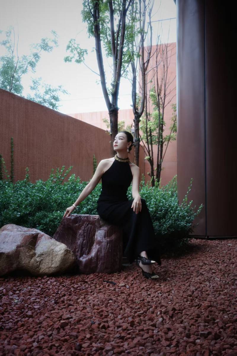 倪妮穿挂脖裙身材曼妙 撑黑伞漫步雨中尽显故事感