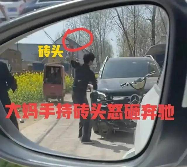 阿姨二话不说,先是用手把奔驰的倒车镜折断,然后用砖头砸碎了倒车镜