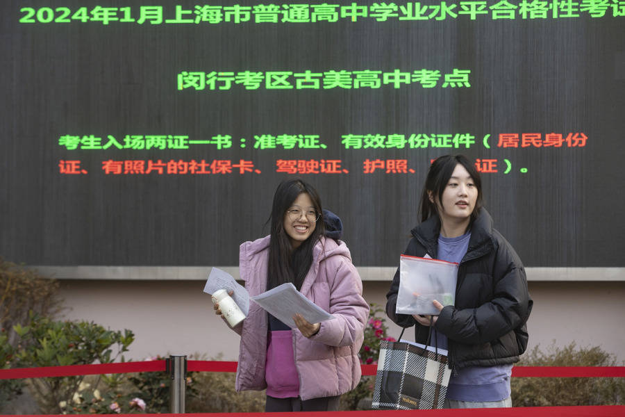 两名考生进入闵行区古美高中考点.工作人员查验考生准考证信息.