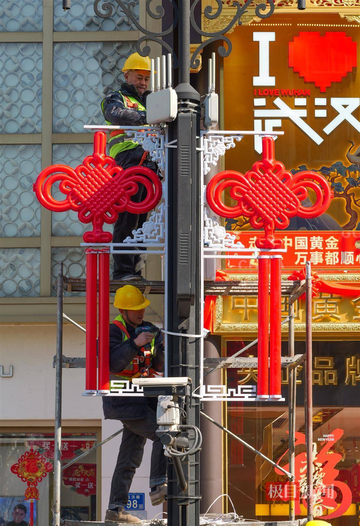 1月25日,武汉江汉路步行街上,工程人员正在沿街路灯杆上安装中国结
