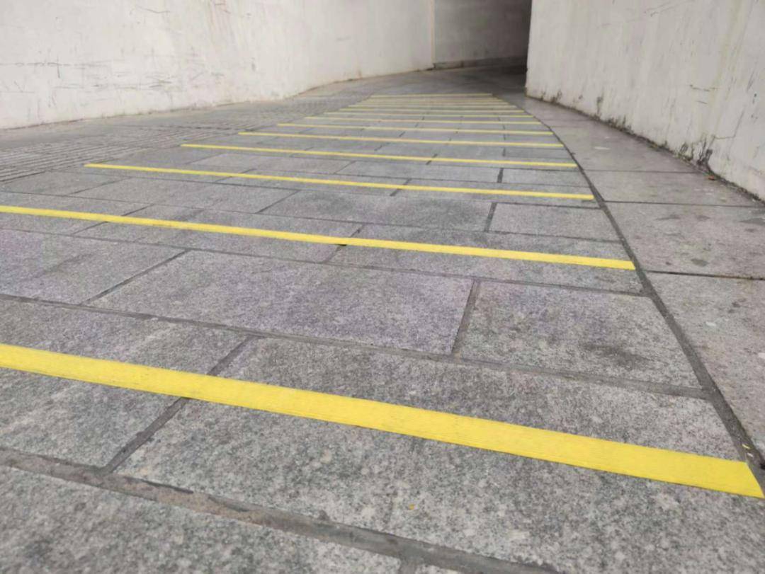 在通道坡度相对较陡路段按板材砖间隔粘贴厚度较小的防滑条,改善路面