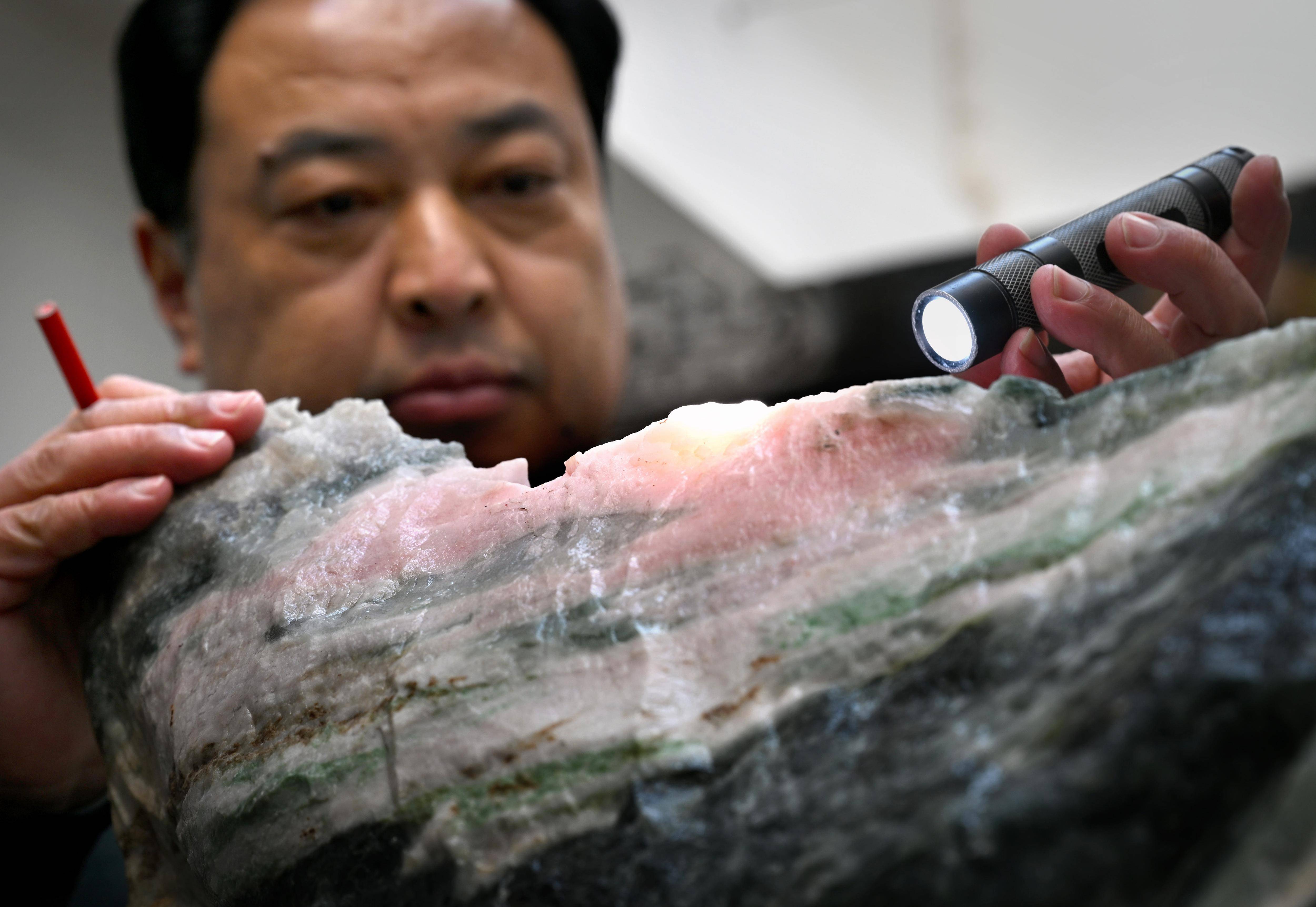 在位于镇平县玉雕大师创意园的"玉神苑"工作室里,刘晓强在查看玉料(1
