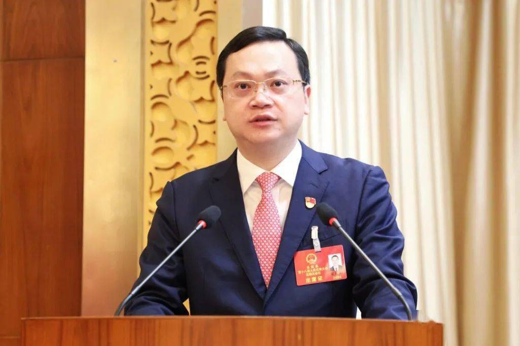 在热烈的掌声中,夏胜利作政府工作报告.