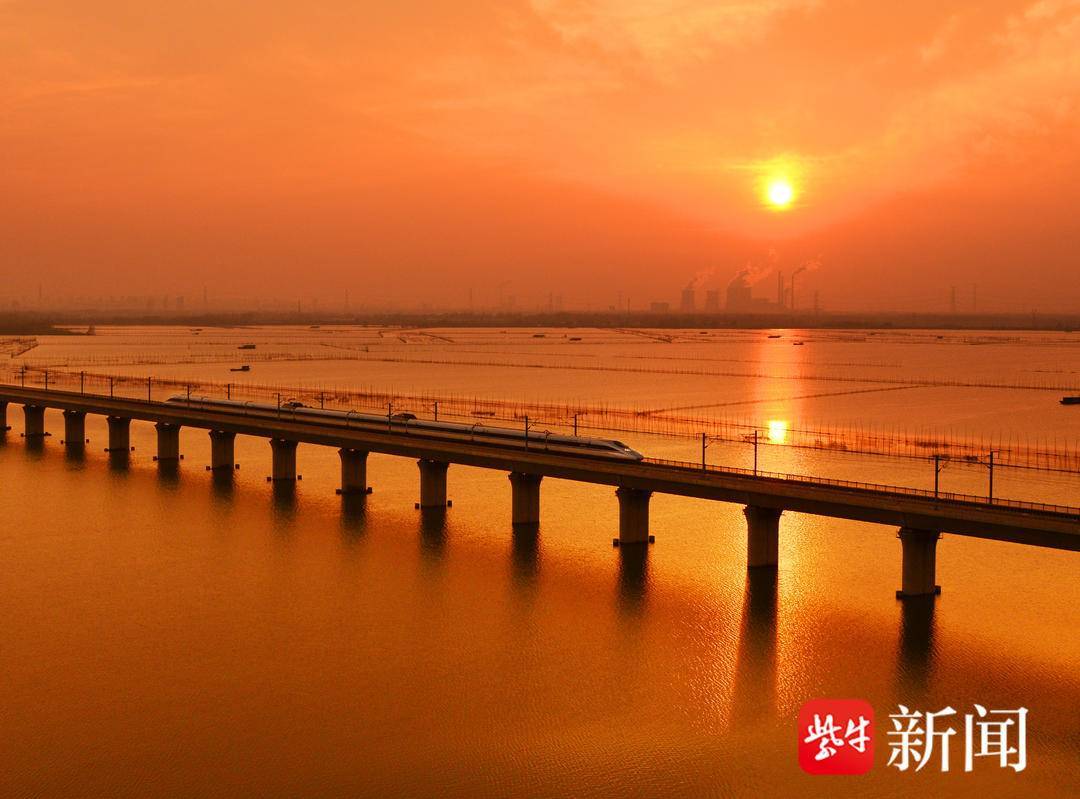 高速列车驶过夕阳下的合蚌高铁高塘湖特大桥 罗春晓 摄立足推进"多网