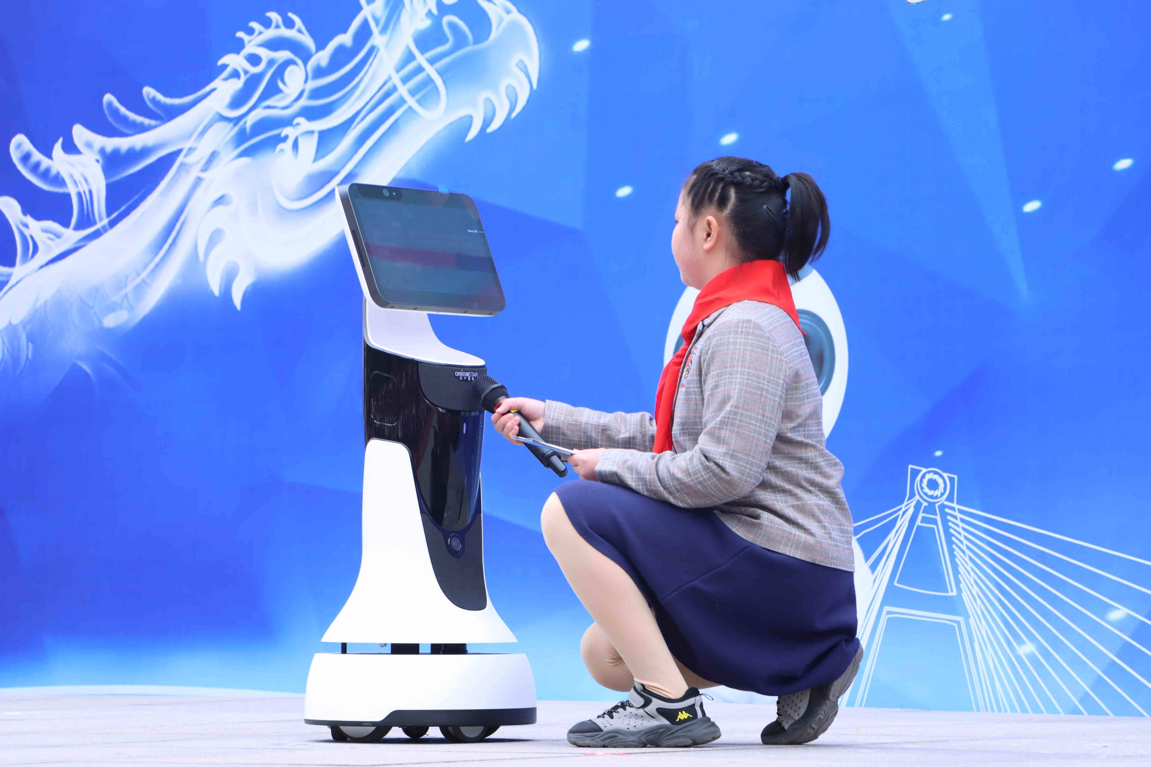 成都七中初中附属小学新成员——智能机器人七仔在与学生代表对话并