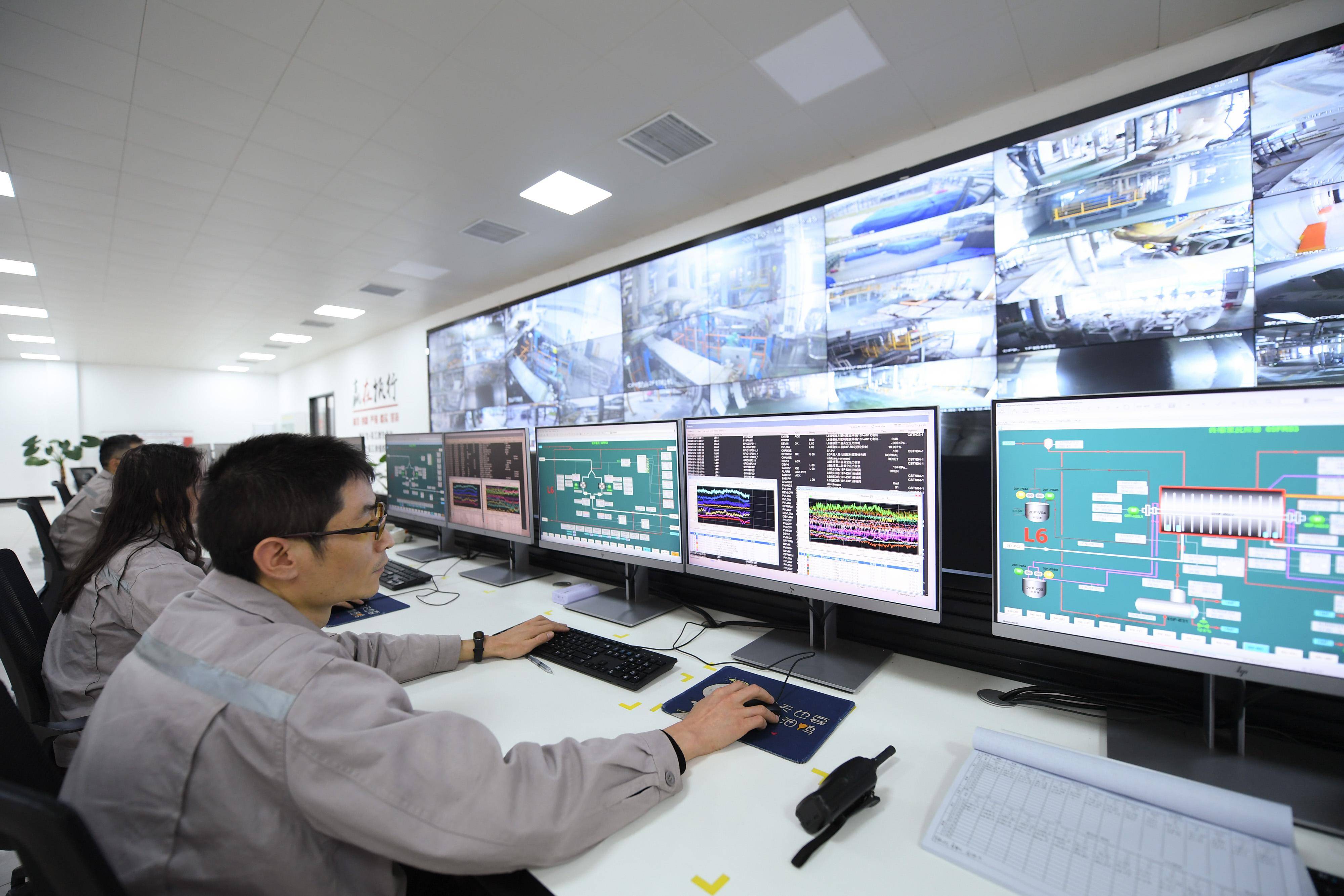 公司聚合车间中控室,工作人员操作中央集散控制系统进行聚酯生产工作