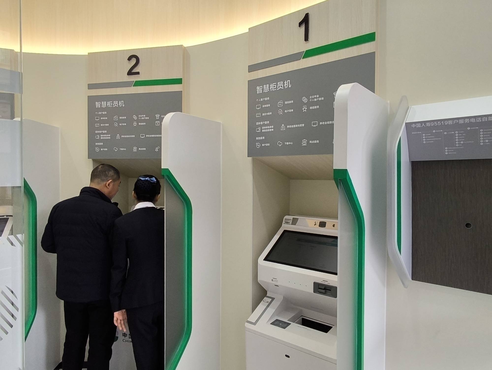 中国人寿厦门同安客户体验中心工作人员引导客户使用智慧柜员机.