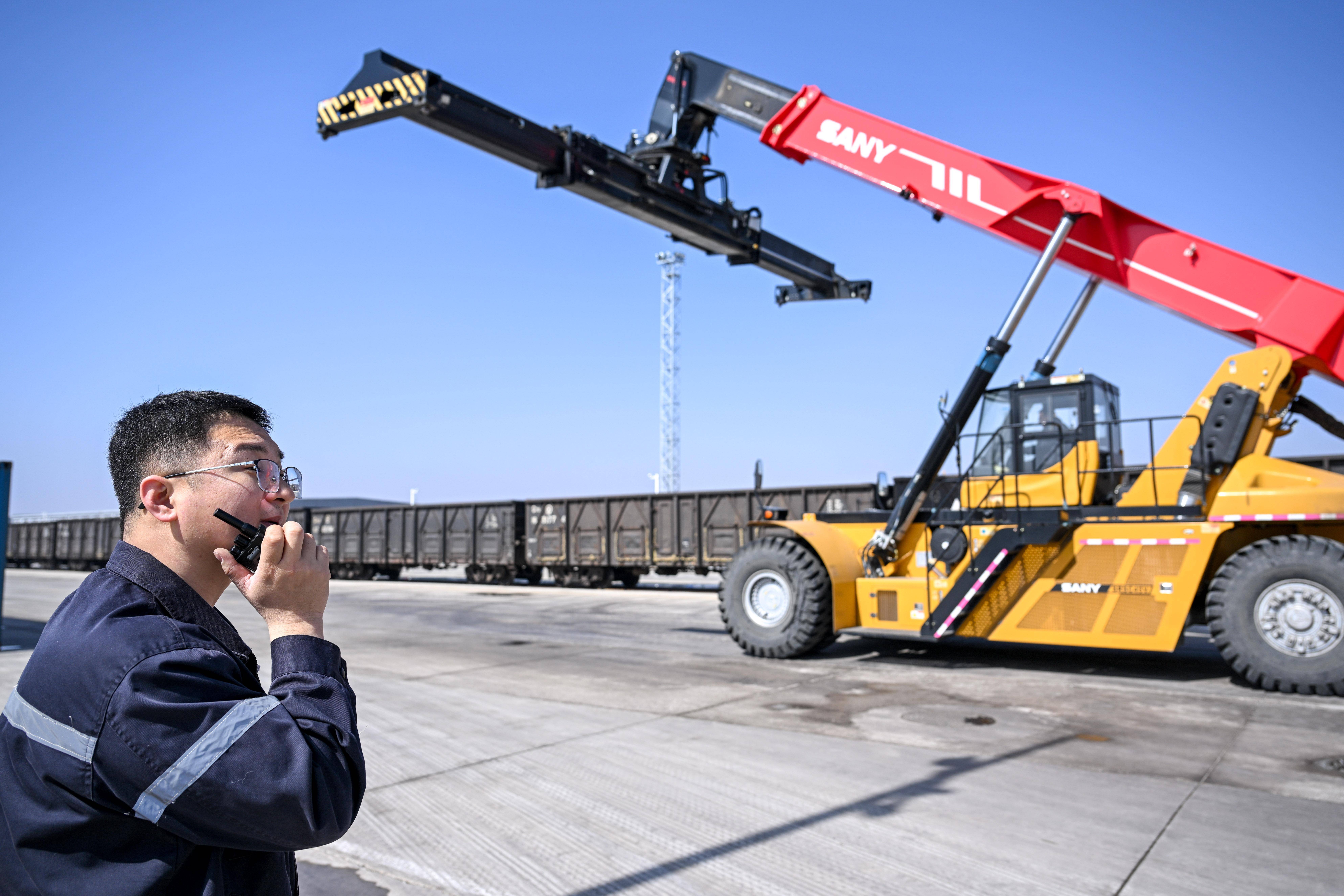 3月25日,工作人员在七苏木铁路国际物流园内调度吊车.