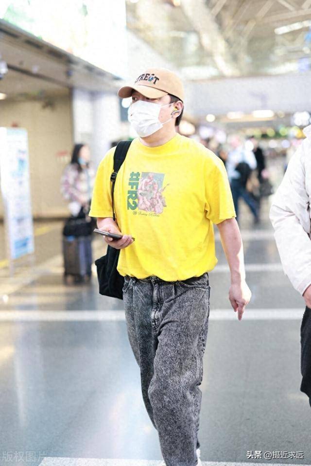 49岁演员黄渤现身北京机场黄色t恤搭配牛仔裤休闲亮眼