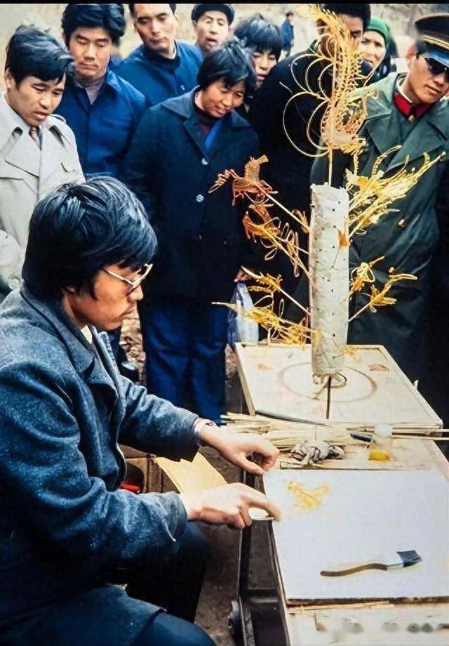 一个糖画师傅在街边给旅客制作糖画.