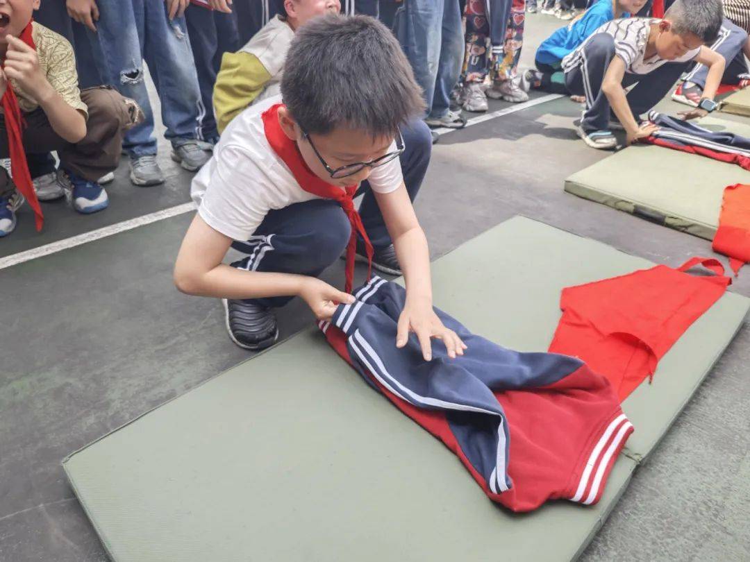 瞧,他们正熟练地进行折叠,展开,铺平,压一压,折叠,拍一拍……服衣叠二