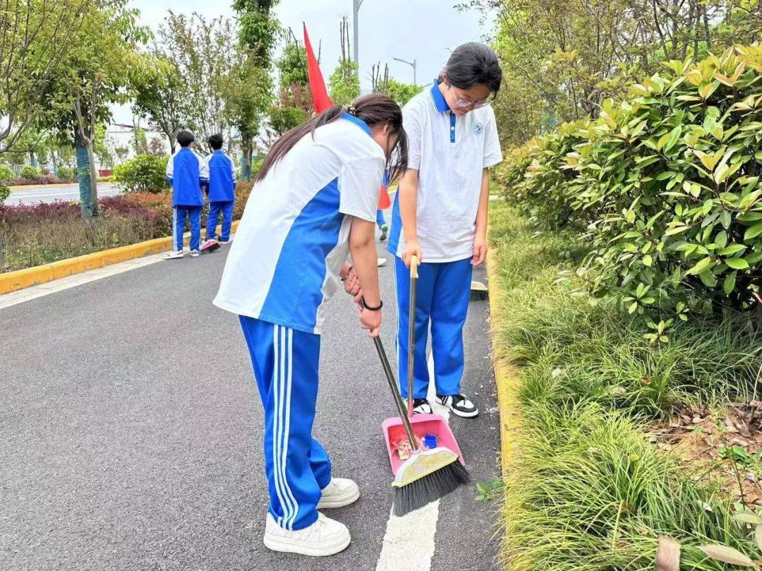 活动当天,学生们身着整齐的校服,手握垃圾袋和清扫工具,犹如一道亮丽