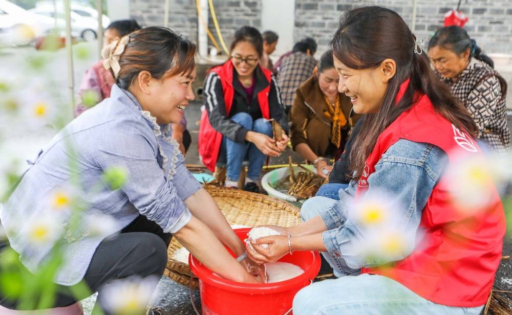 6月4日,垫江县长龙镇高桥社区和龙安村,社区干部和村民在一起洗粽叶