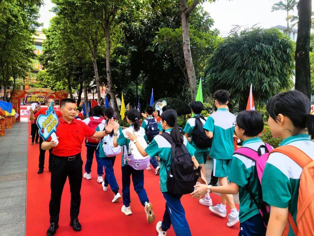 佛山市第三中学初中部的送考团队手持加油牌,为考生打气.