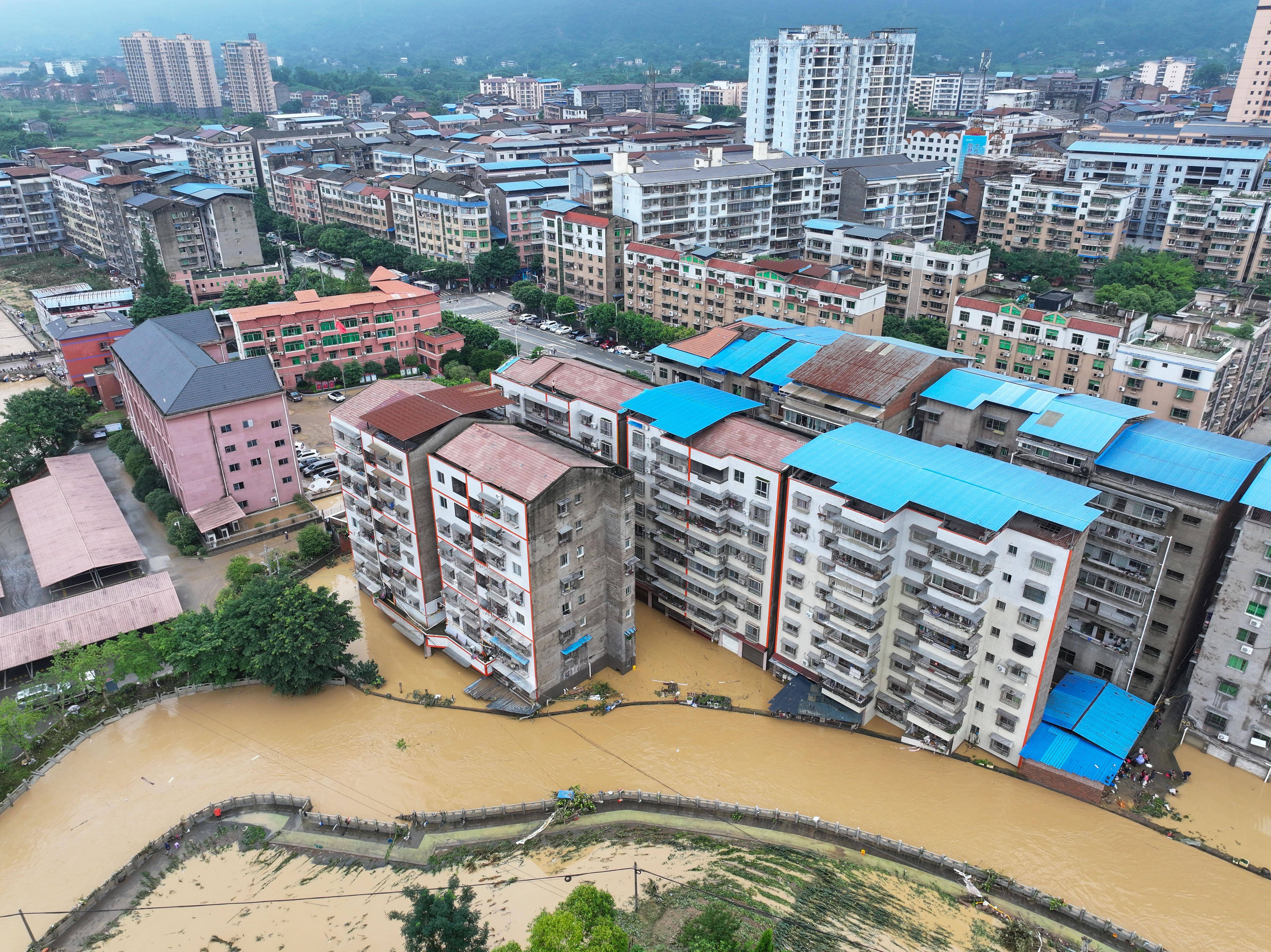 7月11日,重庆市垫江县澄溪镇,抢险人员对泡水车辆进行救援(无人机照片