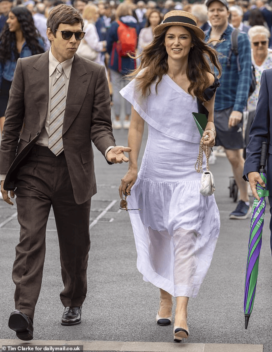 英国演员比如凯拉·奈特莉,穿一身香奈儿,和她丈夫詹姆斯·莱顿一起坐