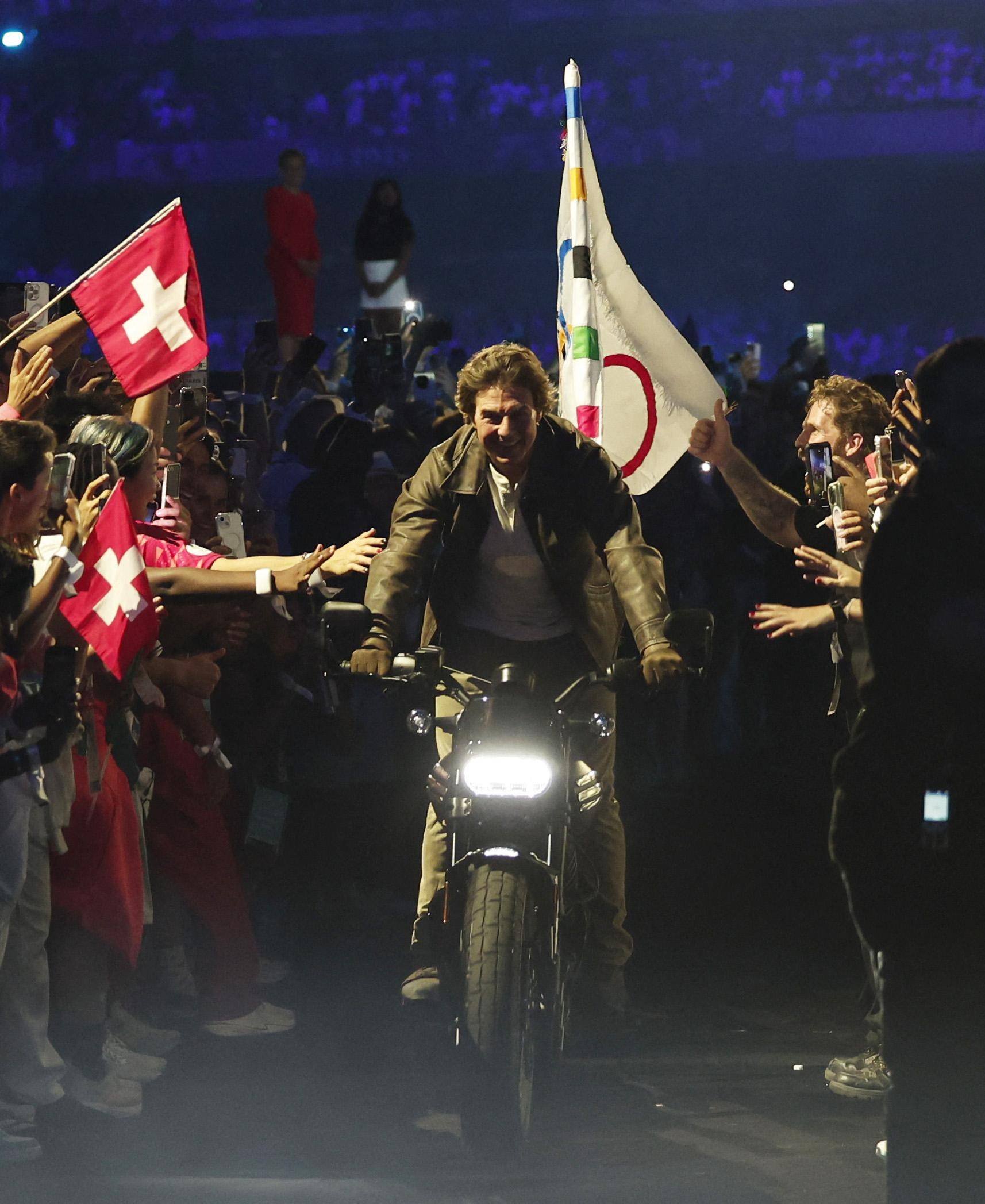 62岁好莱坞巨星汤姆-克鲁斯从天而降 骑机车传递会旗