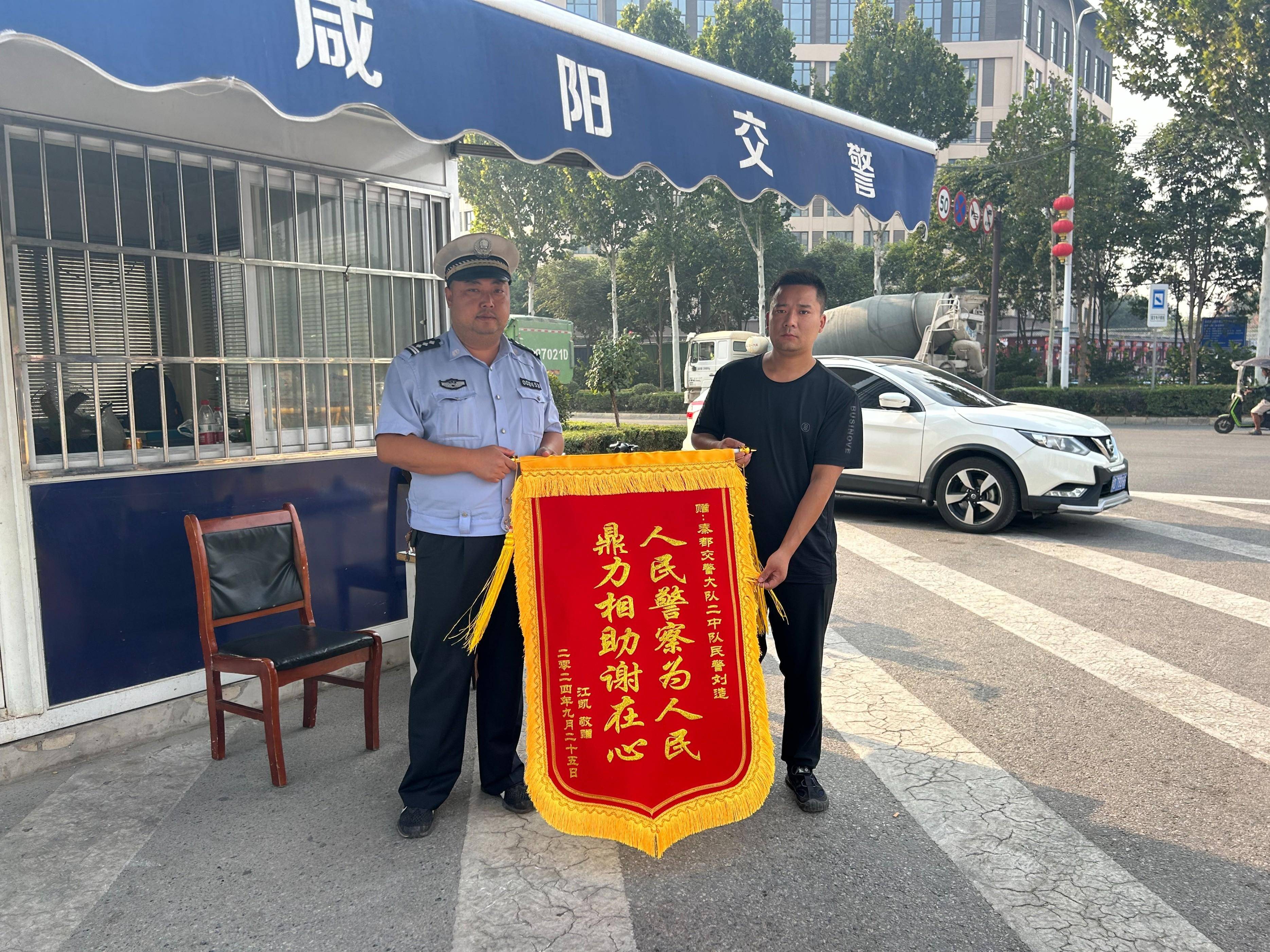 秦都交警车辆故障交警救助群众感激赠送锦旗