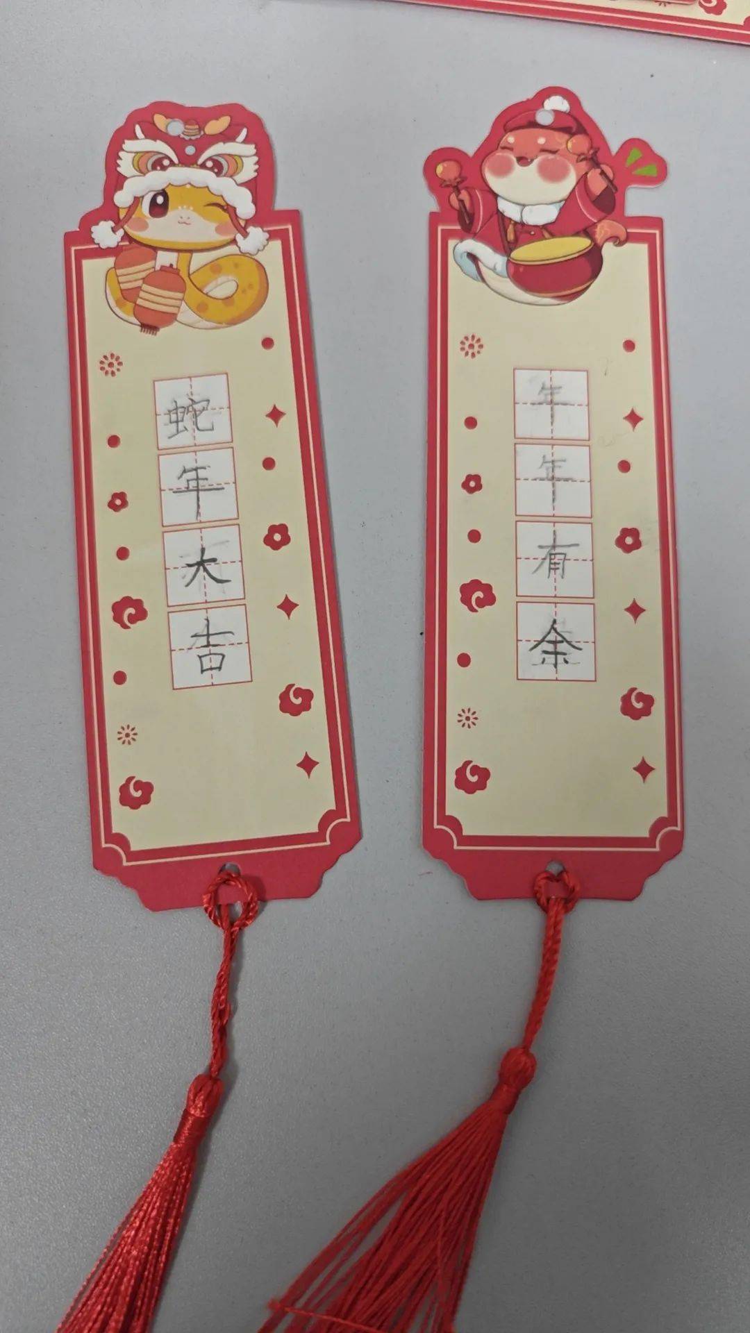 一,二年级的小同学们在书签上郑重地写下一句句祝福语来喜迎新春