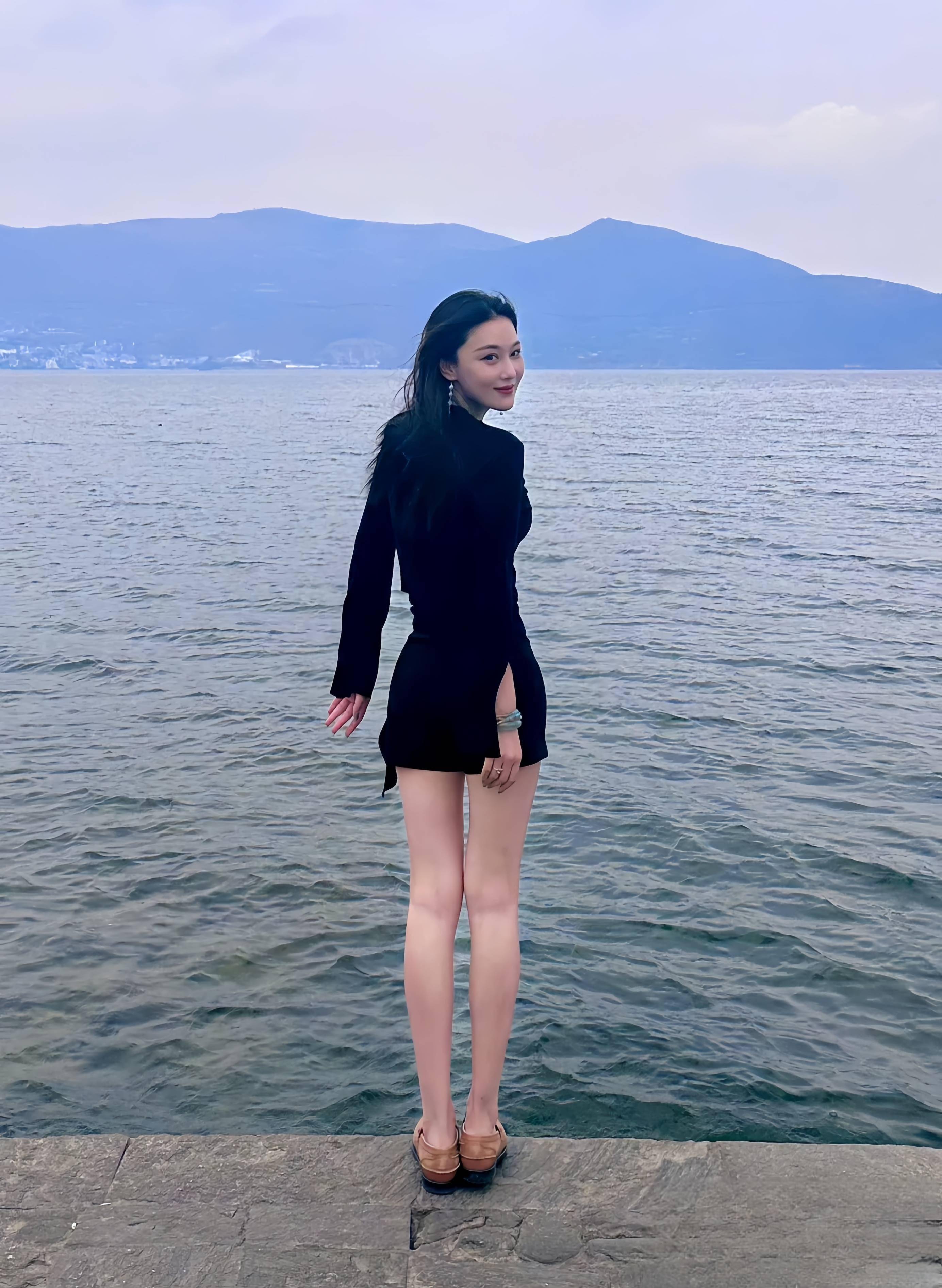 38岁张馨予晒照,扎麻花辫穿格子裙花丛中如精灵,肩宽腰细身材好