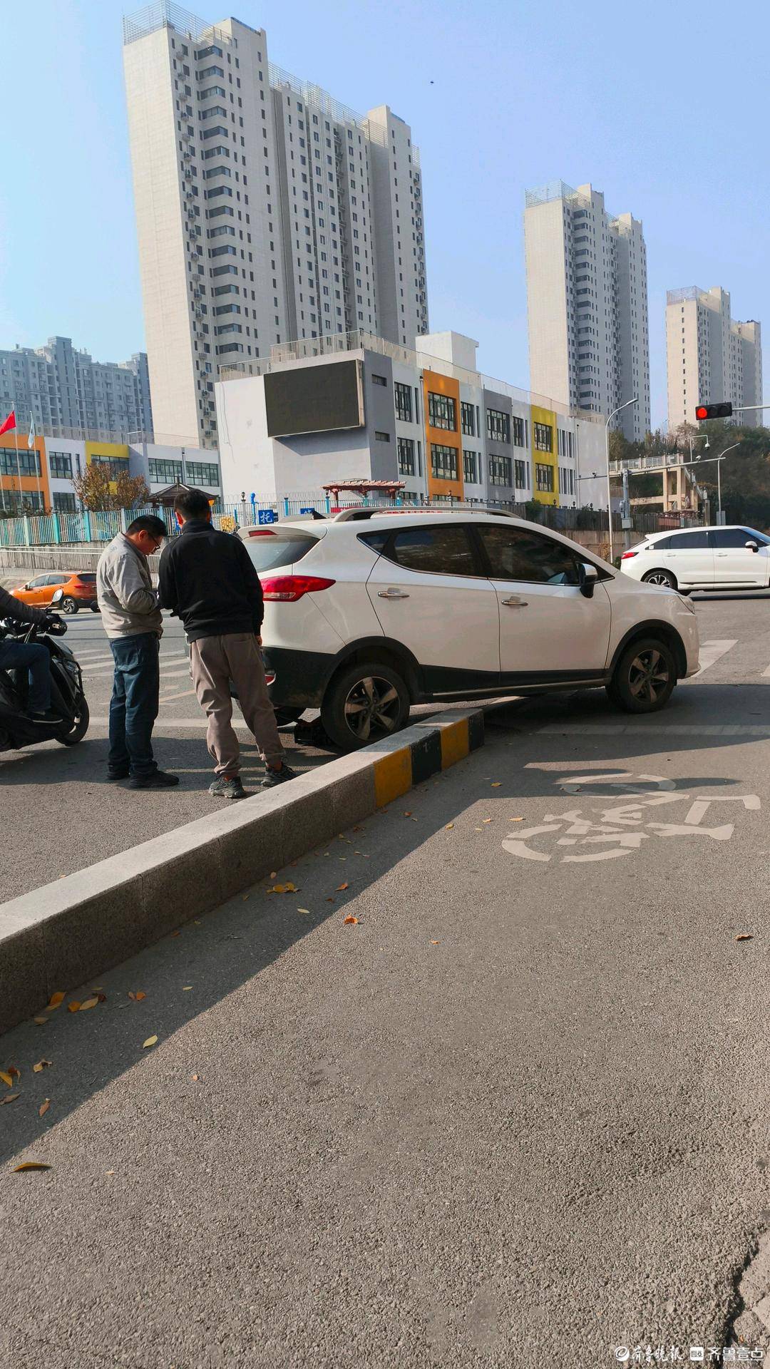 在济南市刘长山路阳光100小学西北路口,一辆汽车意外开到马路牙子上