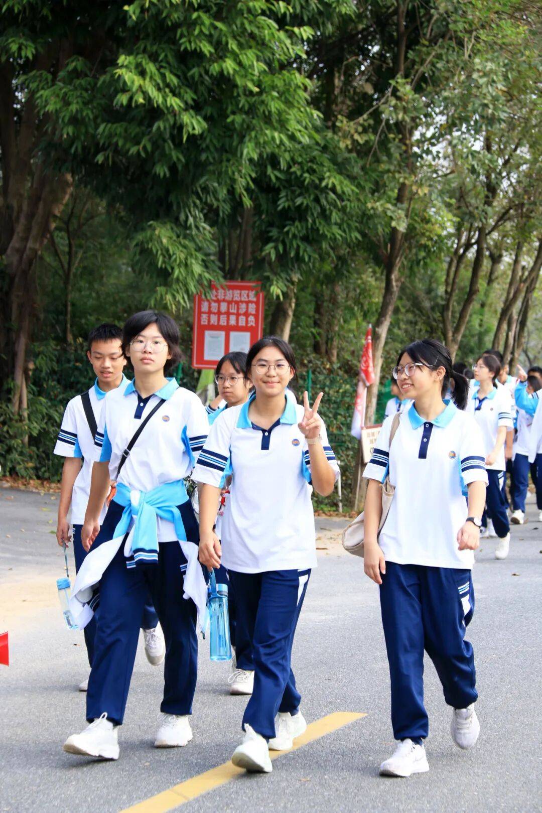 南中学子背着轻便的行囊,穿着整齐的校服,在老师的带领下整装出发