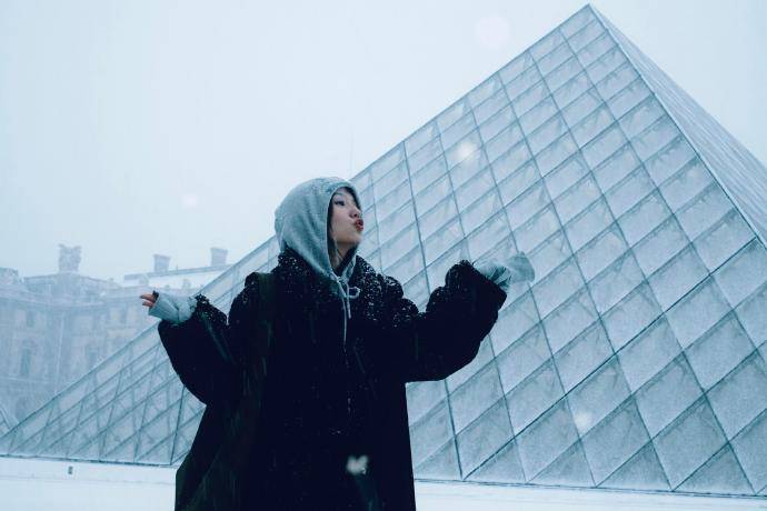 周也晒法国看雪照笑貌灿烂 穿玄色大衣五官讲求